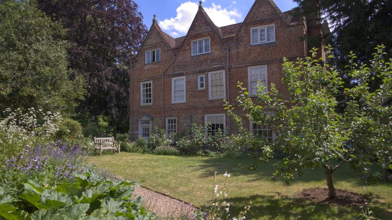 Early Summer Scene at Quebec House, Kent. Apple tree and flowers in the garden.
